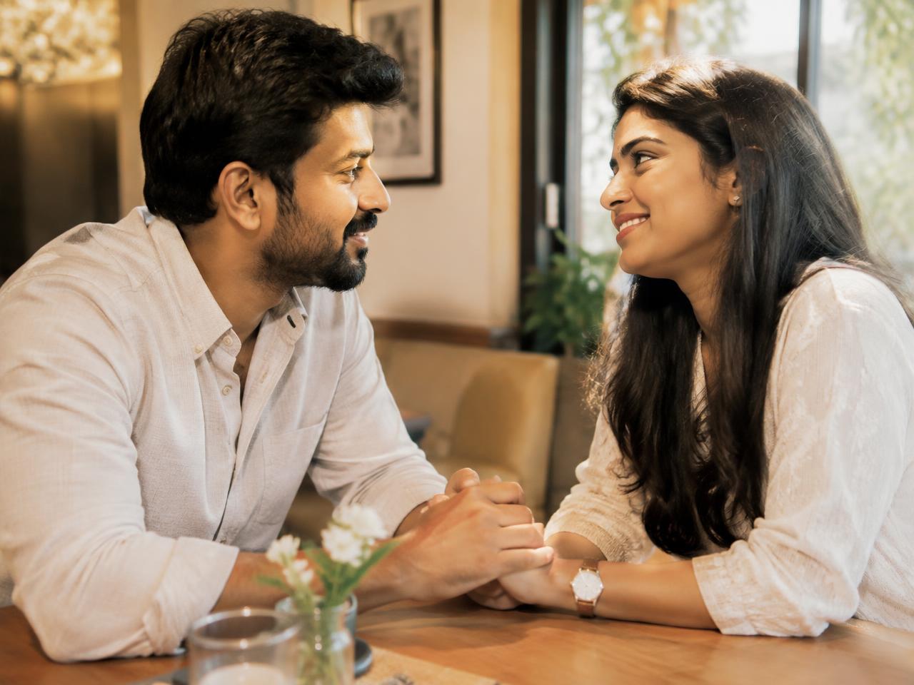 Indian couple holding hands across a cafe table